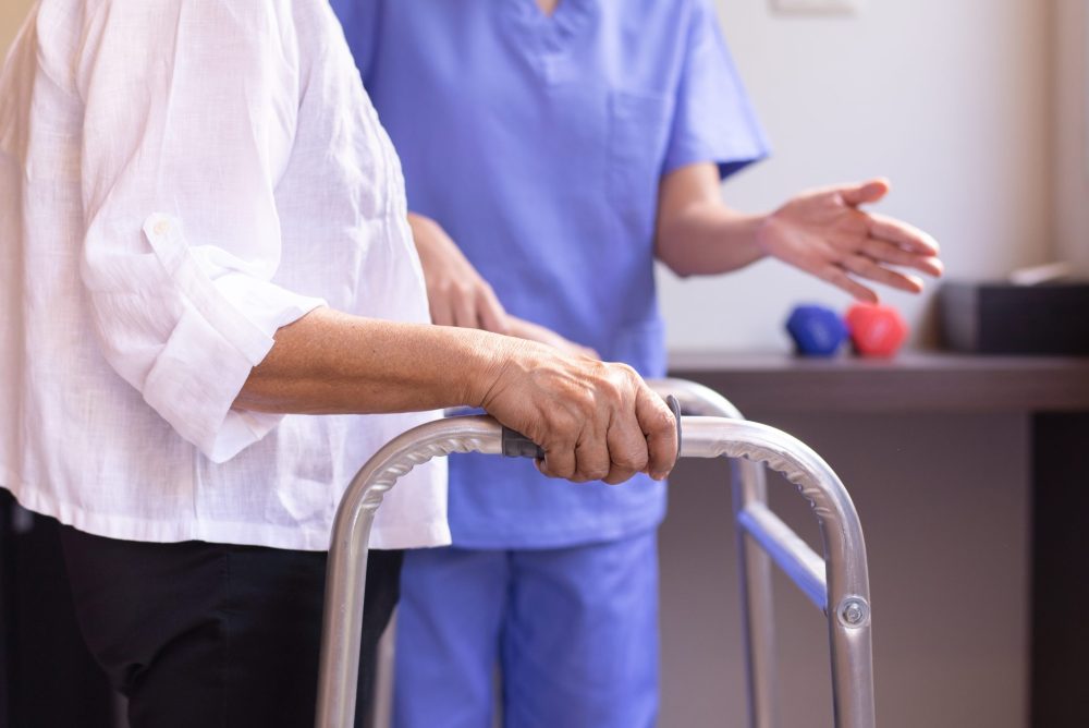 Nurse helping senior woman hand holding walker trying to walk,Care nursing home concept